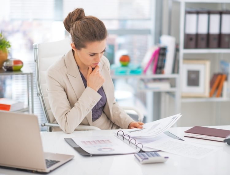 Woman reading business management documents examples