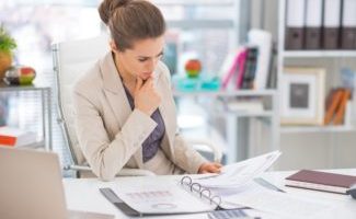 Woman reading business management documents examples